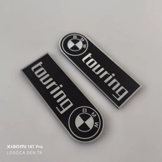 BMW Touring Bir Tarafı Yuvarlak Siyah Üzeri Gümüş Yazılı Plastik Etiket (10x3,5cm)